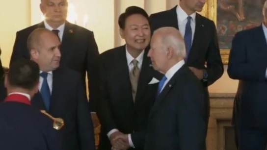 北約峰會，拜登走向拍照區時與尹錫悅握手時，眼睛卻看著保加利亞總統魯門．拉德夫。尹錫悅尷尬地露齒而笑。   圖 : 影片截圖