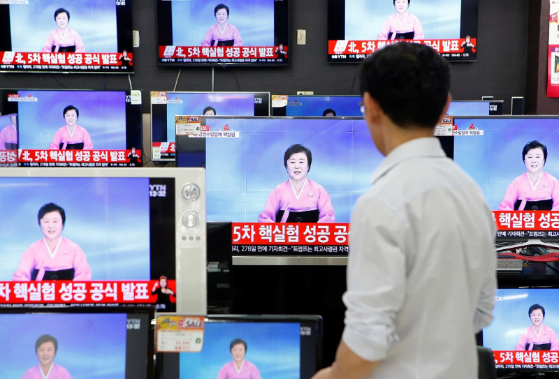 首爾民眾觀看朝鮮中央電視台主播李春姬播報，有關朝鮮當局宣布第5次核子試驗「成功」的新聞。   圖：達志影像/路透社