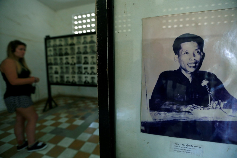 遊客在金邊參觀紅色高棉大屠殺紀念館，圖中照片即為康克由（Kaing Guek Eav）。   圖：達志影像/路透社資料照片