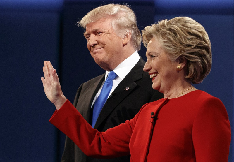 美國總統大選第一場電視辯論當地時間26日登場，希拉蕊以一襲紅色褲裝現身，川普則穿深藍色西裝配藍色領帶，兩人先微笑握手，隨即展開激辯。   圖：達志影像/美聯社