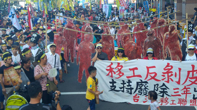 為抗議移工來台3年必須出境1日的規定，上千名移工2日在台北街頭舉辦反剝皮大遊行，呼籲政府儘快修法廢除這項規定。   圖：中央社