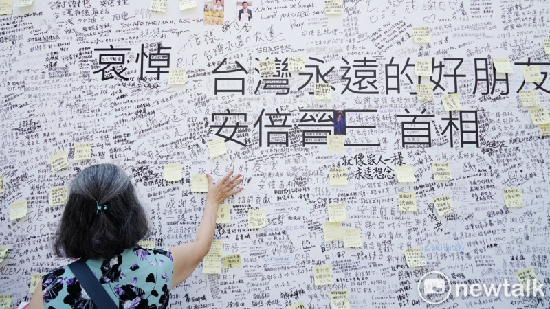 一位民眾將追悼日本前首相安倍晉三的文字貼在日本台灣交流協會台北事務所前。   圖：張良一/攝