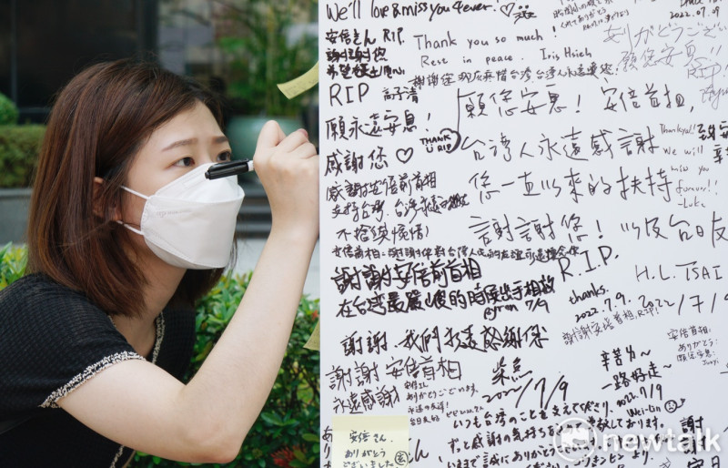 一位民眾在日本臺灣交流協會台北事務所前，寫下對日本前首相安倍晉三的追悼文字。   圖：張良一/攝