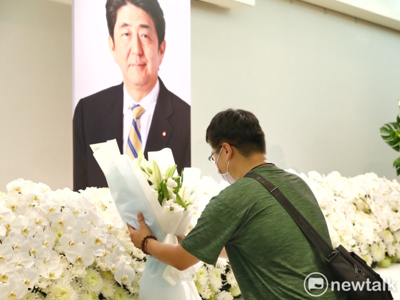 一位民眾在日本臺灣交流協會台北事務所內，向前首相安倍晉三遺像獻花致意。   圖：張良一/攝