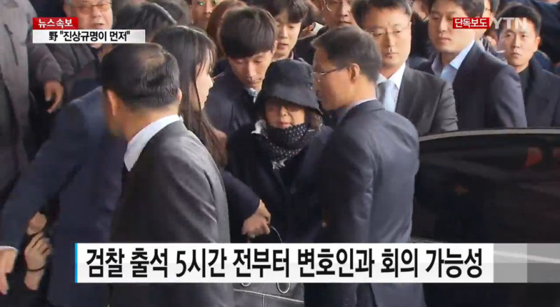 涉嫌干政的韓國總統朴槿惠親信崔順實（中戴帽者），10月31日下午到首爾中央地方檢察廳接受調查，1日證實遭到檢方緊急拘留。   圖：翻攝YTN新聞