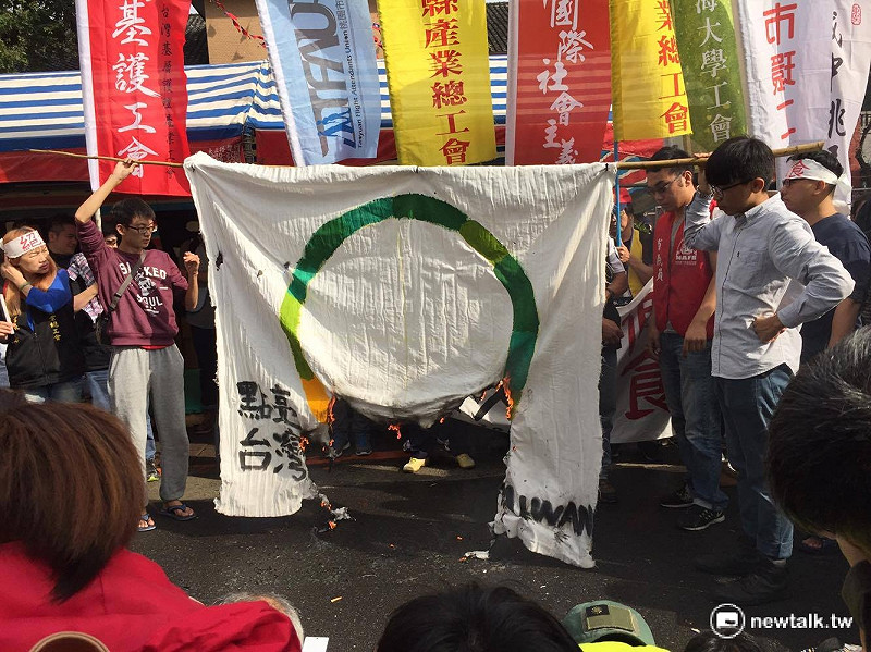勞團4日齊聚立法院外抗議民進黨政府強渡關山《勞基法》修正案，並且怒燒蔡英文選前「點亮台灣」的旗幟。   圖：鄭佑漢/攝