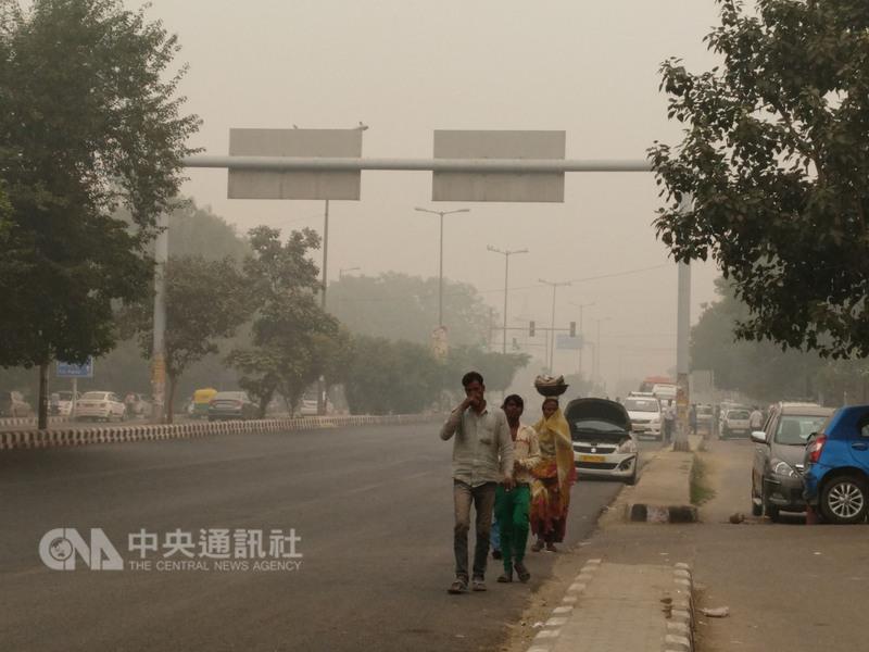 印度首都新德里7日空氣汙染指數破表，一整天都陷入濃濃霧霾中，當地人也忍不住用手掩鼻。    圖：中央社