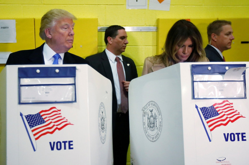 美國共和黨總統候選人川普在投票時，一度偷瞄左邊妻子的動靜。   圖：達志影像/路透社