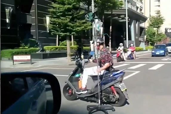 ▲台中阿伯單手騎車邊吊點滴，畫面嚇壞路人。（圖／翻攝自《爆廢公社》）   