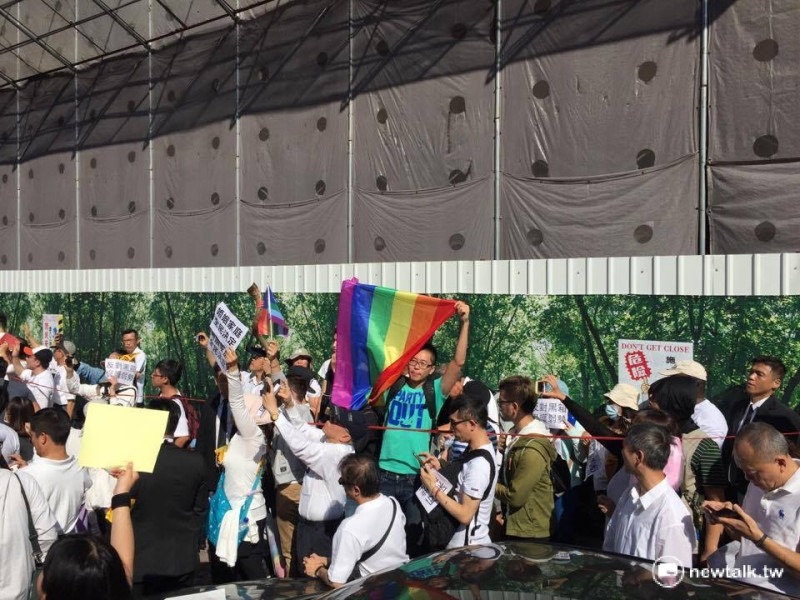 支持婚姻平權的同志也來到現場，手持彩虹旗，與白衣群眾形成強烈對比。   圖：柯昱安/攝