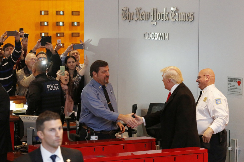 美國總統當選人川普，美東時間22日下午1時許到《紐約時報》總部，與發行人薩茲柏格和其他資深記者會面。圖為川普離開時與保全握手。   圖：達志影像/美聯社。