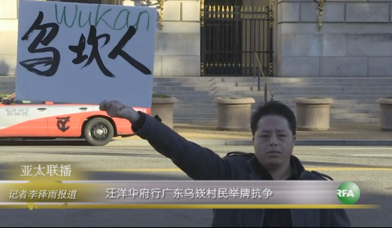 流亡美國的烏坎村前副主任莊烈宏在華盛頓梅隆禮堂前舉牌抗議，為烏坎村民爭取權益。   圖：翻攝自由亞洲電台