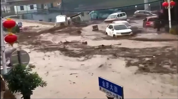 山西省呂梁市中陽縣金羅鎮街道上，可見許多車輛被洪水沖走。   圖：翻攝自騰訊網