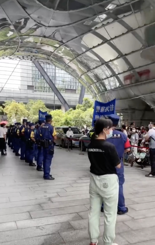 幾百名群眾齊聚在當地中國民生銀行的門口，高喊「民生銀行還錢！」穿著藍色特警制服的公安嚴格戒備，高舉「警察執法，敬請配合」旗幟與群眾對立。   圖：截自推特@yunyunfengfeng