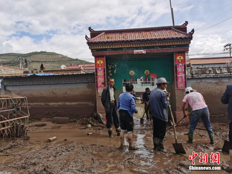 經過今(18)日凌晨暴雨，西寧市大通縣城關鎮的村民正在清除淤積。   圖:翻攝自中新網