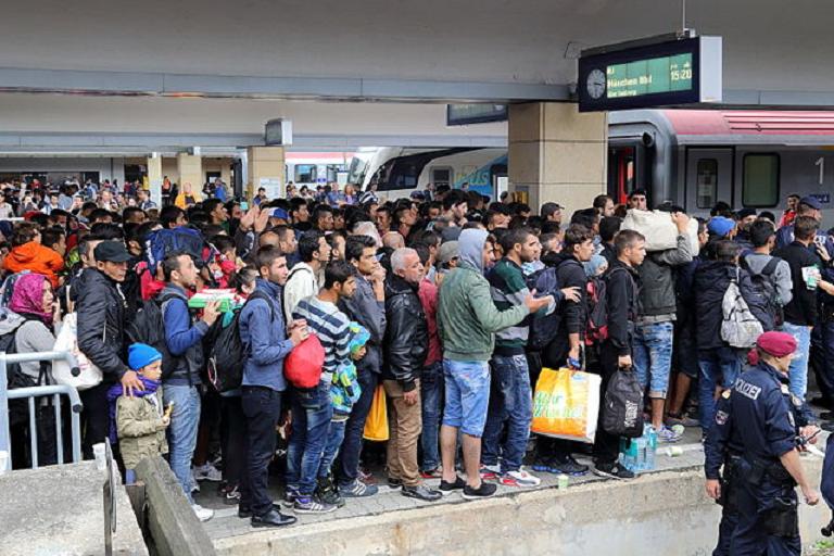 德國官方公布最新資料，顯示過去11個月裡自願離開德國的移民人數高達5.5萬。圖為大批難民聚集在維也納車站，準備搭火車前往德國。   圖：翻攝自維基百科。