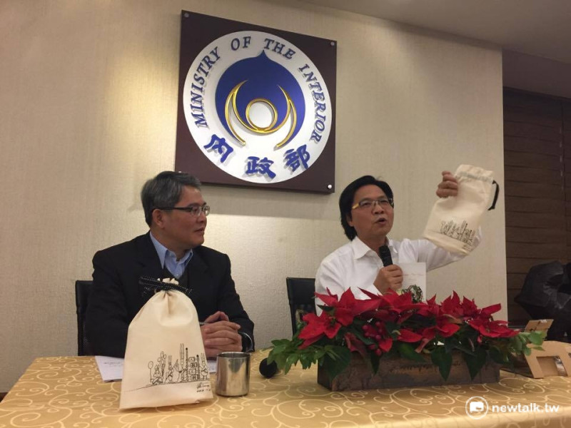 內政部長葉俊榮（右）秀出送給記者的賀歲福袋，外面的插畫是出自自己之手。   圖：柯昱安/攝