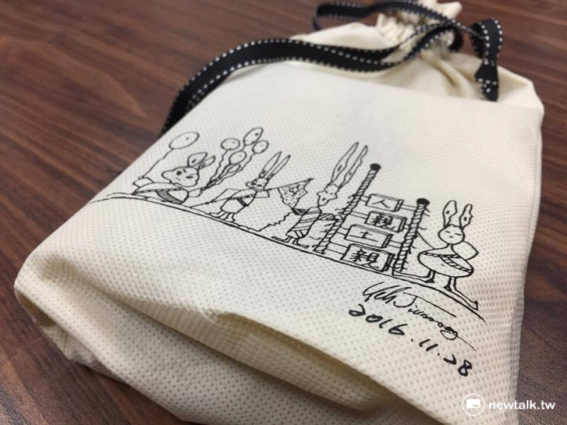 內政部賀歲福袋，外面的「人親土親」插畫是出自內政部長葉俊榮之手。   圖：柯昱安/攝