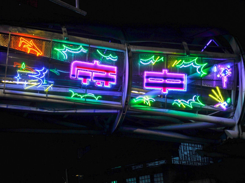遊龍天橋上的霓虹燈裝置藝術，「府中」字樣融入火車意象，述說商圈原址為舊板橋火車站。   圖：新北市經發局提供