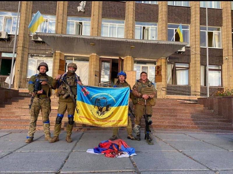 烏克蘭武裝部隊在庫皮揚斯克市政廳前舉起烏克蘭國旗，一面俄羅斯國旗被丟在地上。   圖：翻攝推特