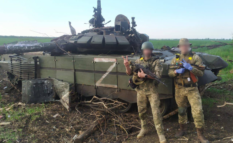 俄烏戰場上，俄軍士兵與裝備損失嚴重。烏克蘭士兵在俄軍遭摧毀的T-80BVM主力戰車殘骸前拍照。   圖：翻攝OSINTtechnical推特（資料照）