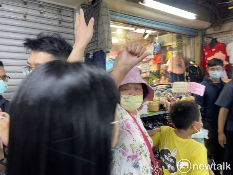 無黨籍台北市長參選人黃珊珊於北投市場掃街，遭一名婦人比倒讚嗆「變色龍」。   圖：周煊惠 / 攝