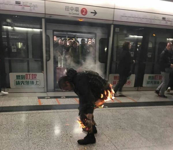 香港一列地鐵10日晚間在九龍尖沙咀站突然起火，導致至少12人受傷。圖為一名乘客身上著火。   圖：中央社(民眾提供)