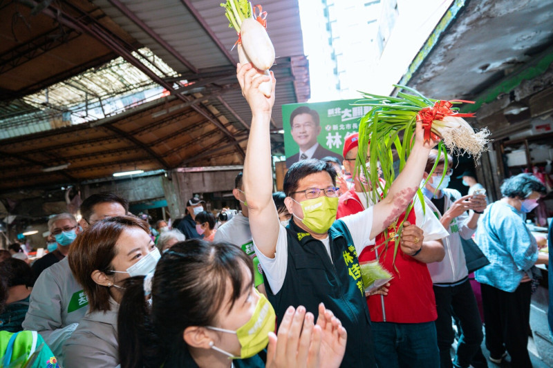 林佳龍今天到板橋湳興市場掃街拜票，攤商送上菜頭、蔥蒜，預祝林佳龍能夠有「好彩頭」、「蔥滿勝蒜（充滿勝算）」。   圖：林佳龍競辦提供