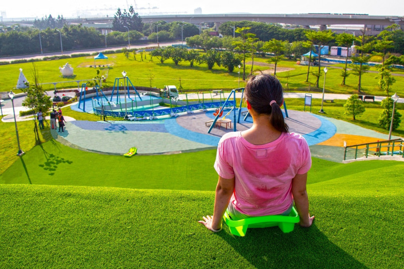 十三行文化公園兒童遊戲場的滑草場是八里必玩景點。   圖：新北市高灘處提供