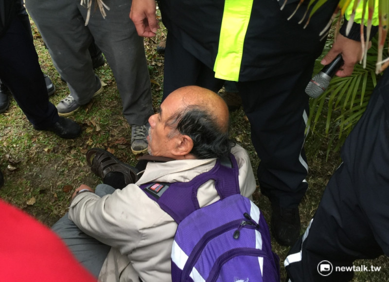 自由台灣黨主席蔡丁貴率眾前進中正紀念堂後，隨後轉往228和平公園抗議，但遭到警方攔阻，只能在草地席地而坐。   圖：柯昱安/攝
