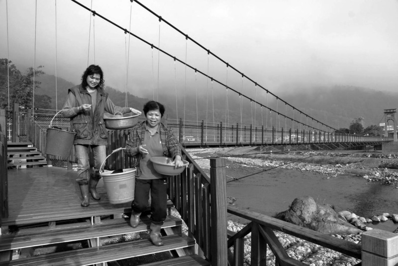 這張黑白照，正是戴金菊與江鳳琴當年在苗栗南庄溪邊洗衣服的照片，是攝影家李湞吉的作品。   圖：台灣水/黃裕順提供