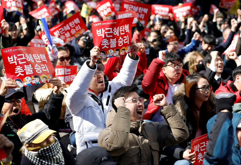 聽到朴槿惠遭彈劾下台後，在憲法法院外的示威民眾高興的歡呼。   圖：達志影像/路透社。