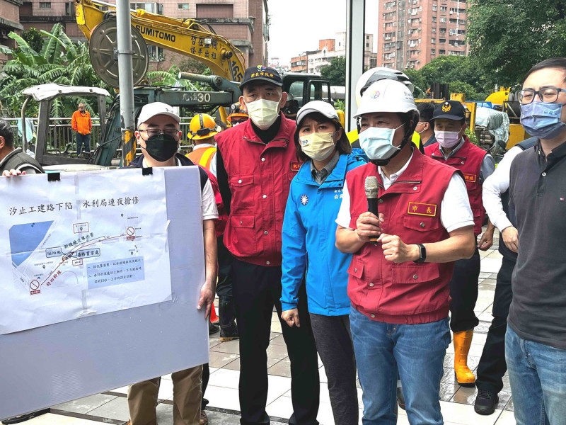 汐止區工建路137號道路下陷，侯友宜及市議員廖先翔（右一）、白珮茹（右三）聽取水利局報告修復進度。   圖：新北市消防局提供