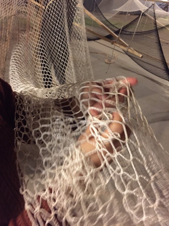 志工們裁量棉線長度後，將線逐一綁上掛網，再將沉重的掛網裝置在天花板上，成為展館內垂掛的棉線意境。
   圖:嘉義縣政府提供