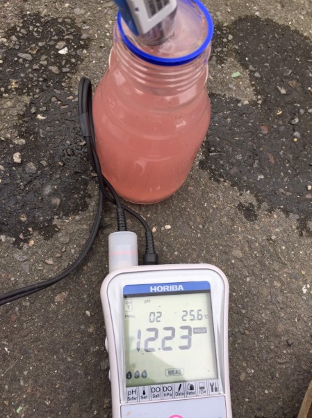  環保局稽查員在二八張溝現場採取粉紅水樣量測pH值為12.23，水溫 25.6 ℃。   圖：翻攝新北市環保局網站