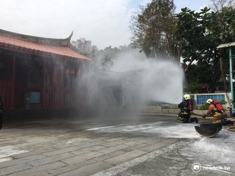 消防隊員以霧狀水柱對大觀書院灑水滅火。   圖：鍾孟軒/攝