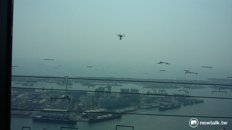 高雄市都發局利用無人機鳥瞰亞洲新灣區，並將影像即時傳送到會場，並作介紹。   圖：金名/攝