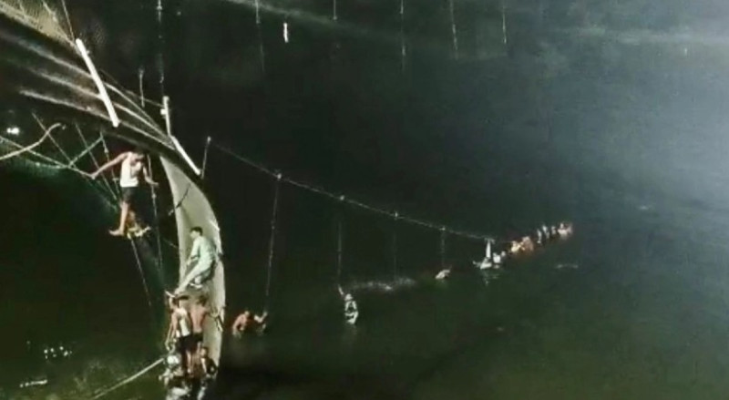 印度最西部的古吉拉特邦古茶拉底省莫比鎮墨丘河上的吊橋．在當地時間下午6時30分左右突然斷裂，橋上數百人瞬間落河，死傷慘重。   圖：翻攝自印度24 NEWS臉書