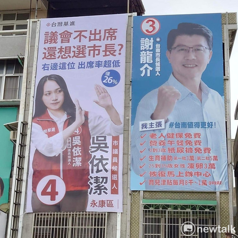 台灣基進台南市永康市議員候選人吳依潔在國民黨台南市長候選人謝龍介的競選看板旁懸掛「議會不出席，還想選市長？」的看板，標題諷刺「右邊這位出席率超低，僅有26%」，批評謝龍介過去在議會表現欠佳。   圖：吳依潔提供