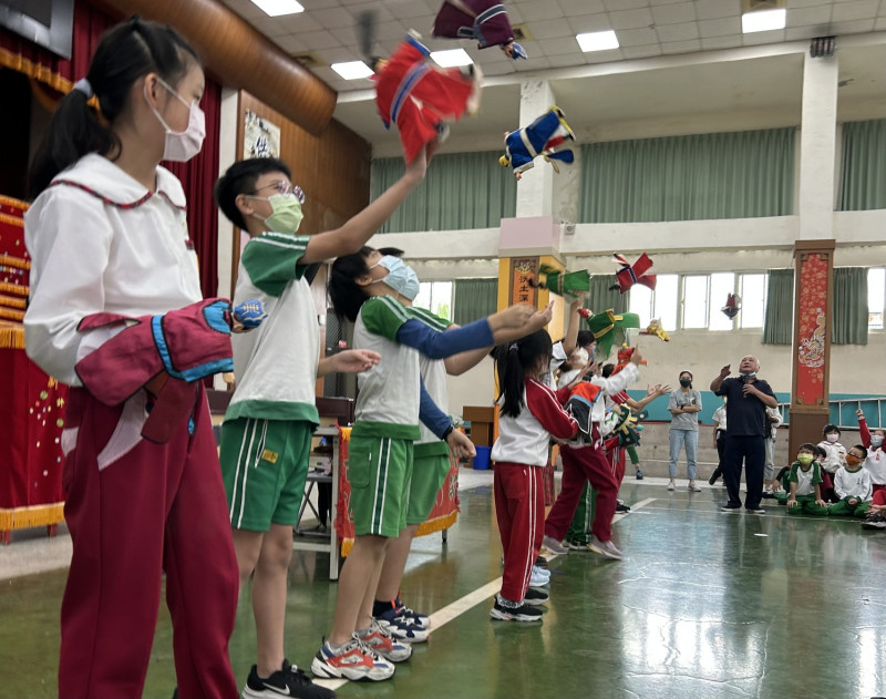 許正宗邀請土城國小學童上台親自體驗操偶，練習高難度「翻跟斗」動作。   圖：新北市文化局提供