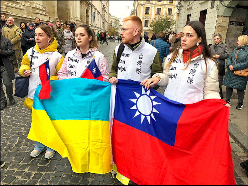 烏克蘭民眾在曾聖光追思場外展示兩國國旗，並穿上「台灣隊」背心，以示對台灣的感謝。   圖：外交部提供