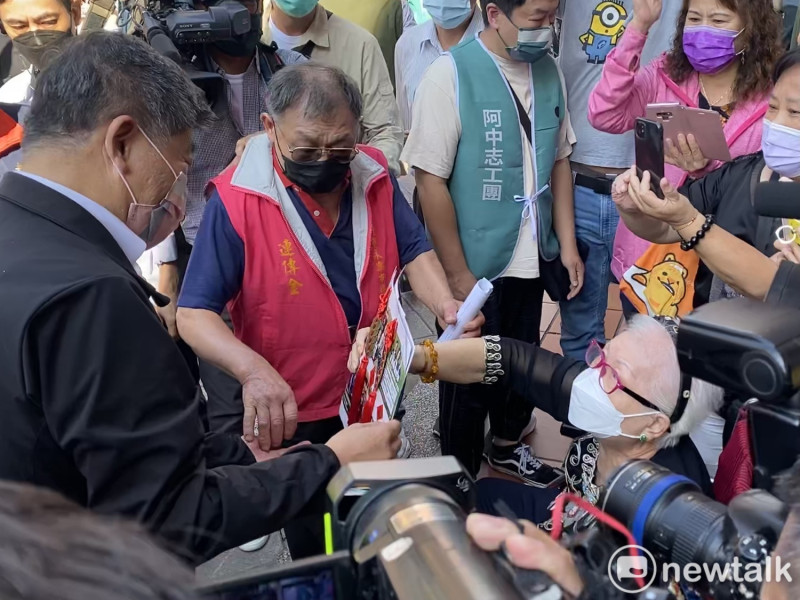 民進黨台北市長候選人陳時中稍早前往永樂市場掃街，一名坐在輪椅上的婦人手持卡片向陳時中表達支持。   圖：周煊惠 / 攝