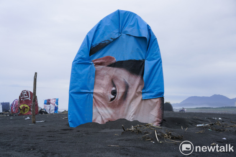 候選人的競選帆布看板被放置在宜蘭蘭陽溪口，作爲扒鰻苗人遮風避雨的小屋。   圖：張良一/攝