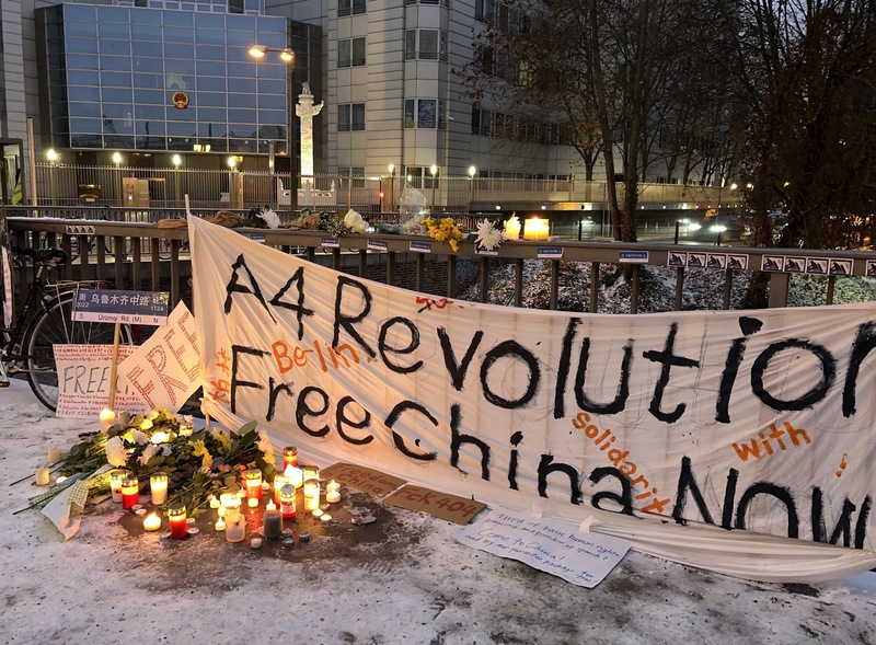 示威群眾在柏林中國大使館前擺鮮花和點蠟燭，悼念烏魯木齊火災的死者。   圖：中央社／提供