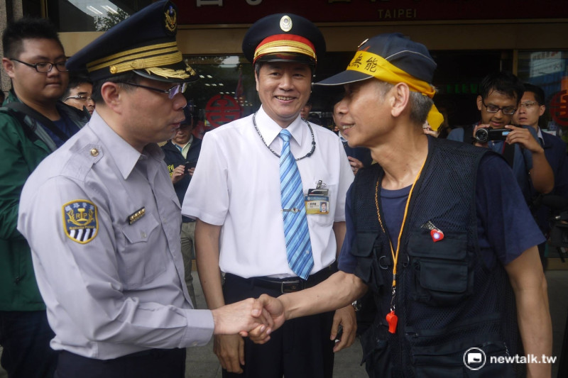 遊行領隊與警方和台北車站站長示意。   圖：鍾孟軒/攝