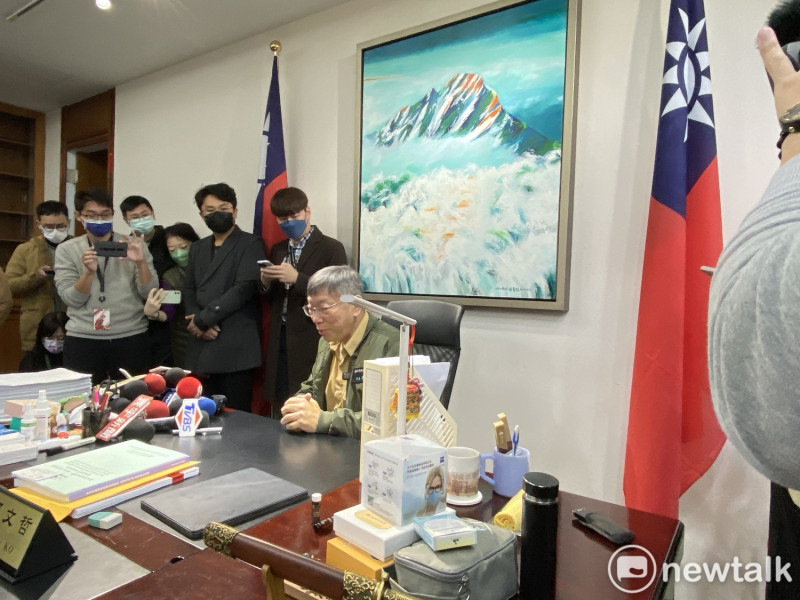 台北市長柯文哲整理市長室，坐在辦公桌上與媒體聊天，並聊到背後的畫作是朋友贈送的。   圖：周煊惠 / 攝