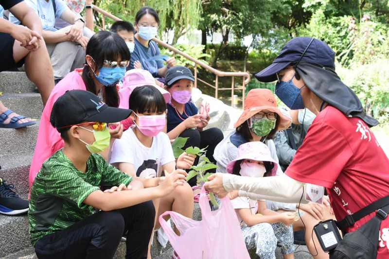 塭仔底濕地公園生態導覽，志工正在向大小朋友介紹植物。   圖：新北市水利局提供