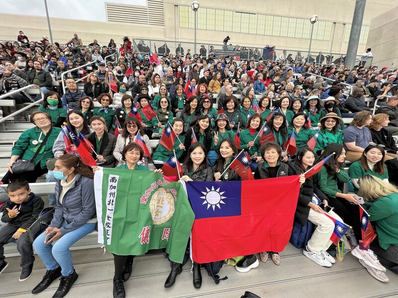 北一女中樂儀旗隊代表台灣，赴美參加玫瑰花車遊行，30日提前在行進樂隊嘉年華上亮相。場邊旅居加州的校友數十人身穿綠色制服、舉國旗，高喊校呼，為場上學妹打氣。   圖：中央社