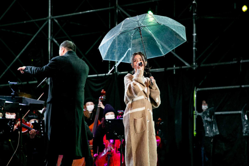 2023年阿里山日出印象音樂會在寒風細雨中登場，歌手撐傘演出。   圖：嘉義縣政府/提供