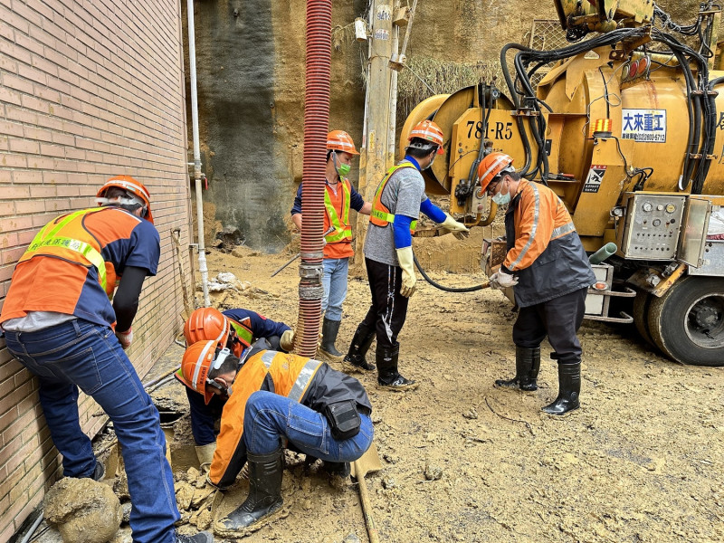 日前汐止暴雨後，清潔隊員前往復原，用人力挖除落土。   圖：新北市環保局提供
